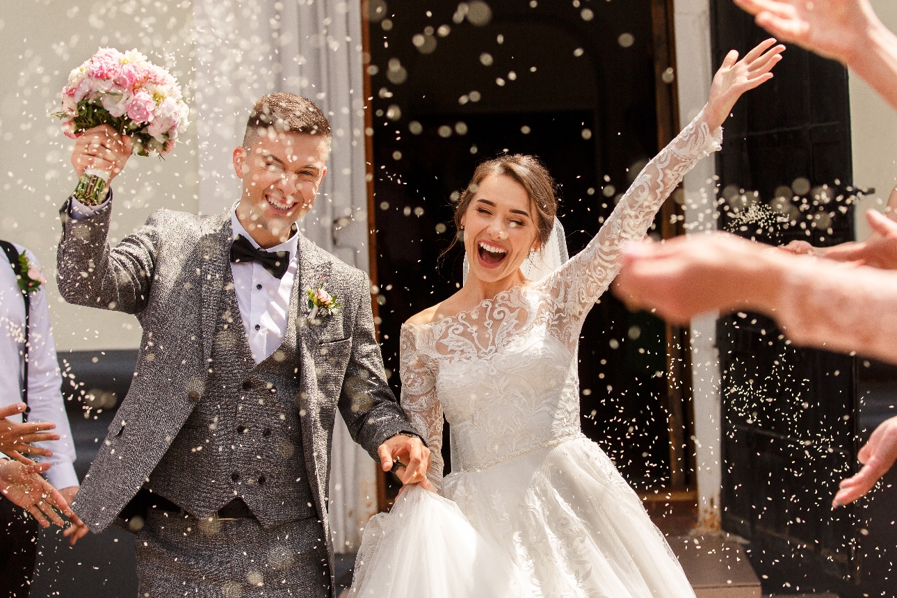 couple cheering under confetti outside venue