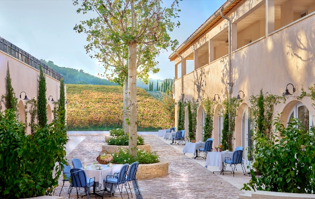 A courtyard with fields and mountains in the background