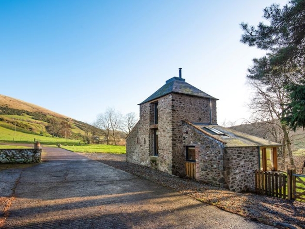 stone cottage at foot of hillside