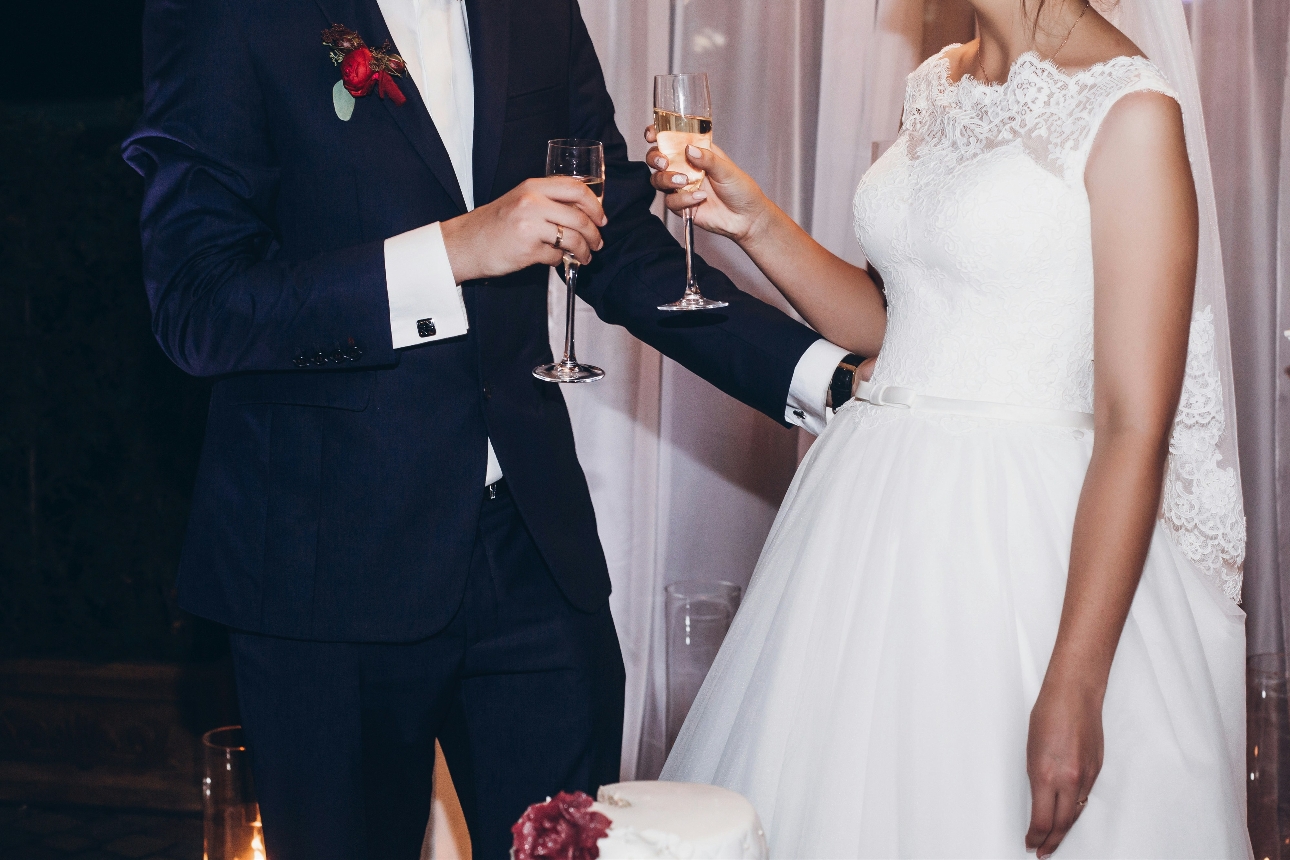 bride and groom with a glass of champagne in each hand