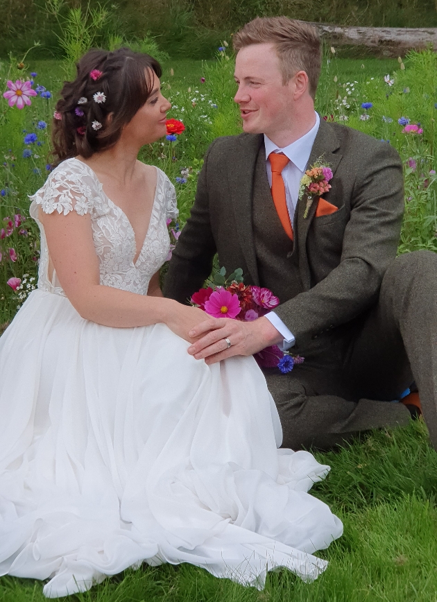 Bride and groom sitting on the grass